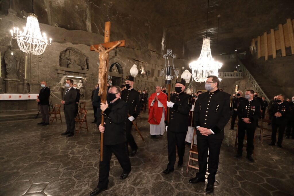 Początek barbórkowej mszy. Przed arcybiskupem Jędraszewskim idzie górnik z drewnianym krzyżem